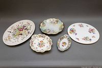 Photo showing varied porcelain dishes including Royal Worcester platter, Union T oval dish, and others with floral designs