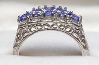 Side profile showing white gold filigree band and amethyst settings