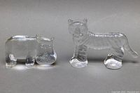 Front view of clear glass hippo and tiger paperweights showing detailed shapes and finish