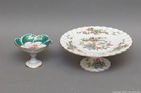 Blue pagoda-shaped porcelain pedestal bowl with multicolor floral pattern and gold trim, shown from angled side view