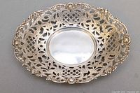 Top view of oval silver dish showing reticulated openwork design and smooth center area.