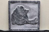 Front full view of square carved alabaster marble relief sculpture plaque depicting mother cradling child signed David Bernett