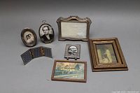 All items arranged showing various framed photos and prints with visible wear.
