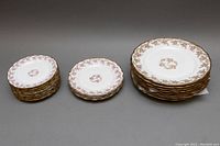 All plates stacked by size showing floral and gold trim features.