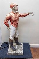 Front view of painted concrete jockey statue on square base
