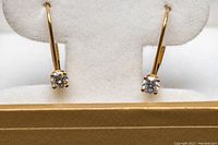 Front view of earrings showing diamond solitaires