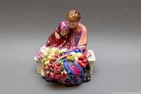 Front view showing two children on a bench with colorful bouquet of flowers, detailed hand painting and glazing visible.