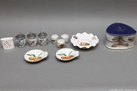 Overview shot showing all porcelain items in the set including ashtray, ramekins, egg coddlers, toothpick holder, bowls, and cups.