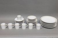 Full shot showing all dishware in the set grouped by type including dinner plates, luncheon plates, dessert plates, mugs, and saucers.