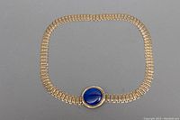 Full view of the gold toned metal link belt shaped in a rounded square to show the overall design and length.
