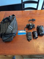 Overview of all items included in the lot: camera with lens, flash, bag, lens pouch and instruction manual.