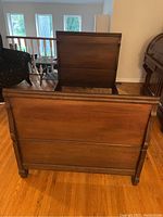 Photo of the antique wooden bed frame headboard and footboard against wall