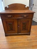 Front view of an antique solid wood dry sink cabinet with drawer and two-panel doors.