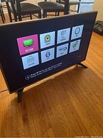 Front view of the LG 43-inch TV turned on showing settings menu with picture, audio, channel, time options.