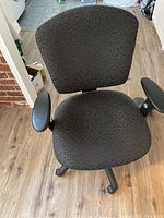 Top view of the office chair displaying the patterned fabric upholstery and padded armrests.