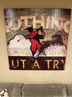 Front view of the square golf-themed wall print hanging on the wall above a couch.