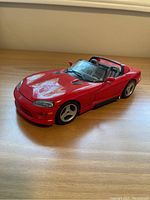 Red Dodge Viper RT model car with convertible top, detailed interior, and smooth finish.
