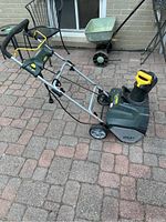 Side and front view of green Yardworks electric snowblower showing overall condition and design.