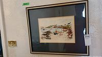 Framed wall art hung on wall, showing overall appearance with black frame and cream matting, with size label 9x13 visible