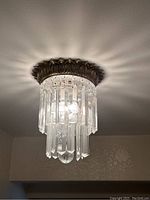 Crystal ceiling light mounted on ceiling showing its design and reflective shadows