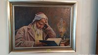 Full view of the framed oil painting showing the man studying by lamplight.
