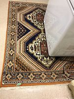 Partial view of area rug showing geometric pattern and border