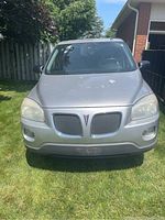 Front view of silver minivan showing hood, grille, headlights with paint chips