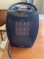 Front view of the black GiveBest space heater showing metal mesh grill and internal heating elements lit