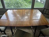 Photo of Danish walnut dining table top surface showing overall wood finish and shape with leaf insert seam visible