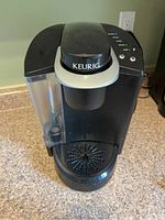 Front view of Keurig coffee maker showing water reservoir and drip tray.