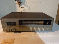 Front view of Lloyds stereo radio and cassette player showing cassette slot, control buttons, and wood grain finish.