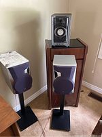 Overall setup photo showing Sony CD/radio player sitting atop a wooden cabinet, flanked by two JVC speakers on black stands.