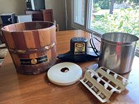 Photo of all components of the Vintage Sterling Ice Cream Maker including wooden bucket, motor, metal canister, cracking lid and mixing paddles on a table.