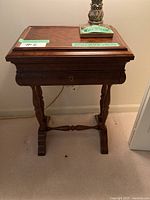 Front view of wooden Bombay side table showing smooth flat top and turned legs with lock keyhole visible.