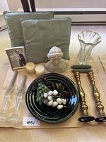 Full lot photo showing stone bust, grapes, glass candlesticks, brass candle holders, vase, candles, and framed photo