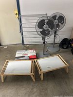 Photo of fans, drying rack, wooden trays, and boxed Toshiba DVD recorder VCR in storage setting.