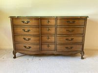 Front view of vintage 12-drawer wooden dresser with glass top, showing drawer arrangement and ornate handles.