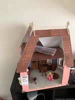 Side view of the handmade doll house showing exterior roof and partial interior.
