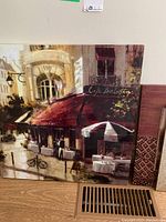 Colorful cafe street scene canvas print leaning against wall