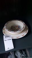 Stacked view of the Royal Doulton Bunnykins plate and bowl with visible bunny border and colorful cottage bunny scene inside bowl.