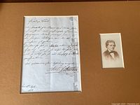 Letter and photograph removed from frame, displayed on mat board