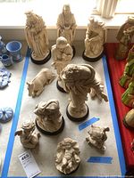 Overall view of the nativity figurines arranged on a surface, showing all eleven pieces including bases.