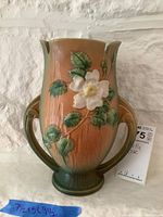 View of the handled vase outward showing floral motif and two decorative handles.