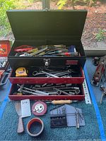Union Super Steel black toolbox with two red drawers, open to show various hand tools inside and in drawers with additional tools laid out in front.
