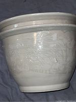 Side view of large white porcelain flower pot showing glossy finish and slight surface texture.