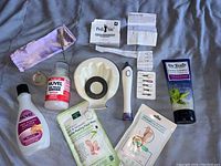 Photo shows all items including electric nail drill, foot creams, nail polish remover, and accessories spread out on a cloth.