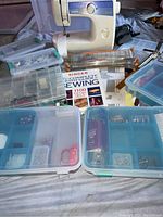 Overall view showing Brother sewing machine, organized storage cases with sewing items, and sewing guides.