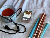 Photo showing the ceramic electric wax burner, three scented taper candles, and pack of scented wax melts arranged on a fabric surface.