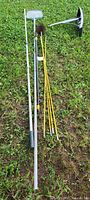 Full lot of chimney brushes, extendable poles, metal scoop, and chimney sections laid on grass.