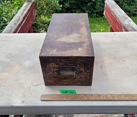 Front view of vintage oak card holder drawer showing metal handle and label holder with ruler for scale.